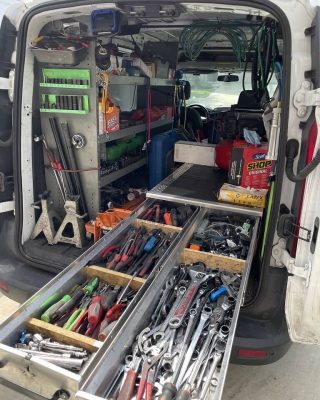 A van with an open back filled with various tools, ready for a work project or service call.