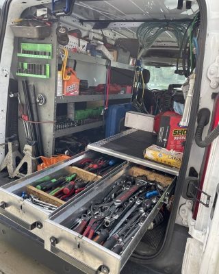A van with an open back filled with various tools, ready for a work project or service call.