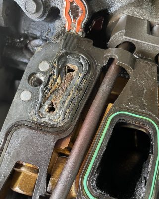 Close-up of a car engine showing a broken part, highlighting mechanical damage and potential repair needs.