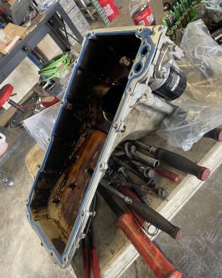 A metal toolbox with various tools placed on top, showcasing a collection of hand tools and equipment.