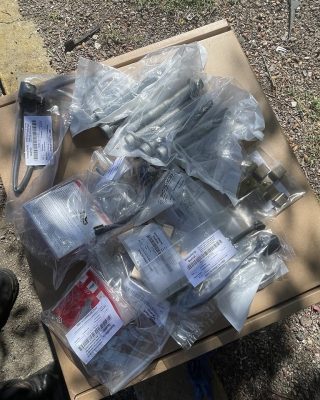 A table cluttered with various plastic bags and tools, showcasing a disorganized workspace.