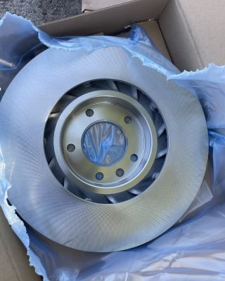 Brake disc packaged in a box with blue wrapping, showcasing its protective and presentational features.