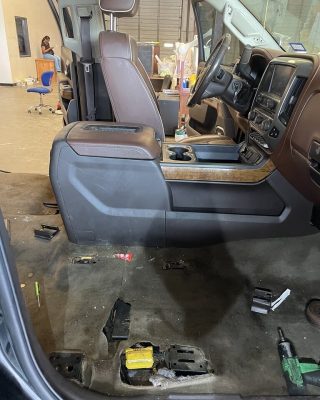 Inside view of a truck featuring a driver's seat and a steering wheel, showcasing the vehicle's interior design.