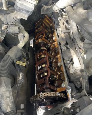 Car engine with a visible chain and chain link, showcasing mechanical components and their interconnection.