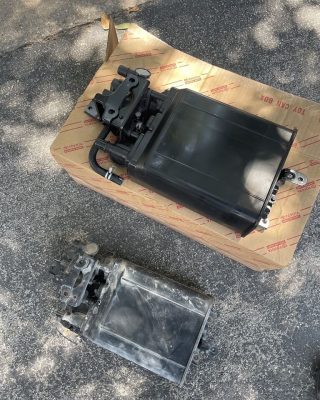 A black box with a small battery placed on top, showcasing a simple electronic setup.