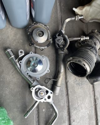 A disassembled car engine and various parts are scattered on the ground, showcasing automotive components.