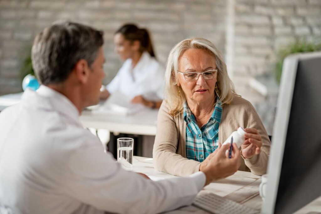 A mid-50s woman checks the prescription bottle provided by her doctor for hormone replacement therapy.