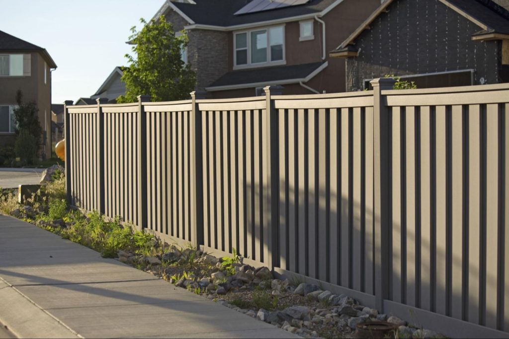 A wood grain vinyl fence surrounding the outside of a home.