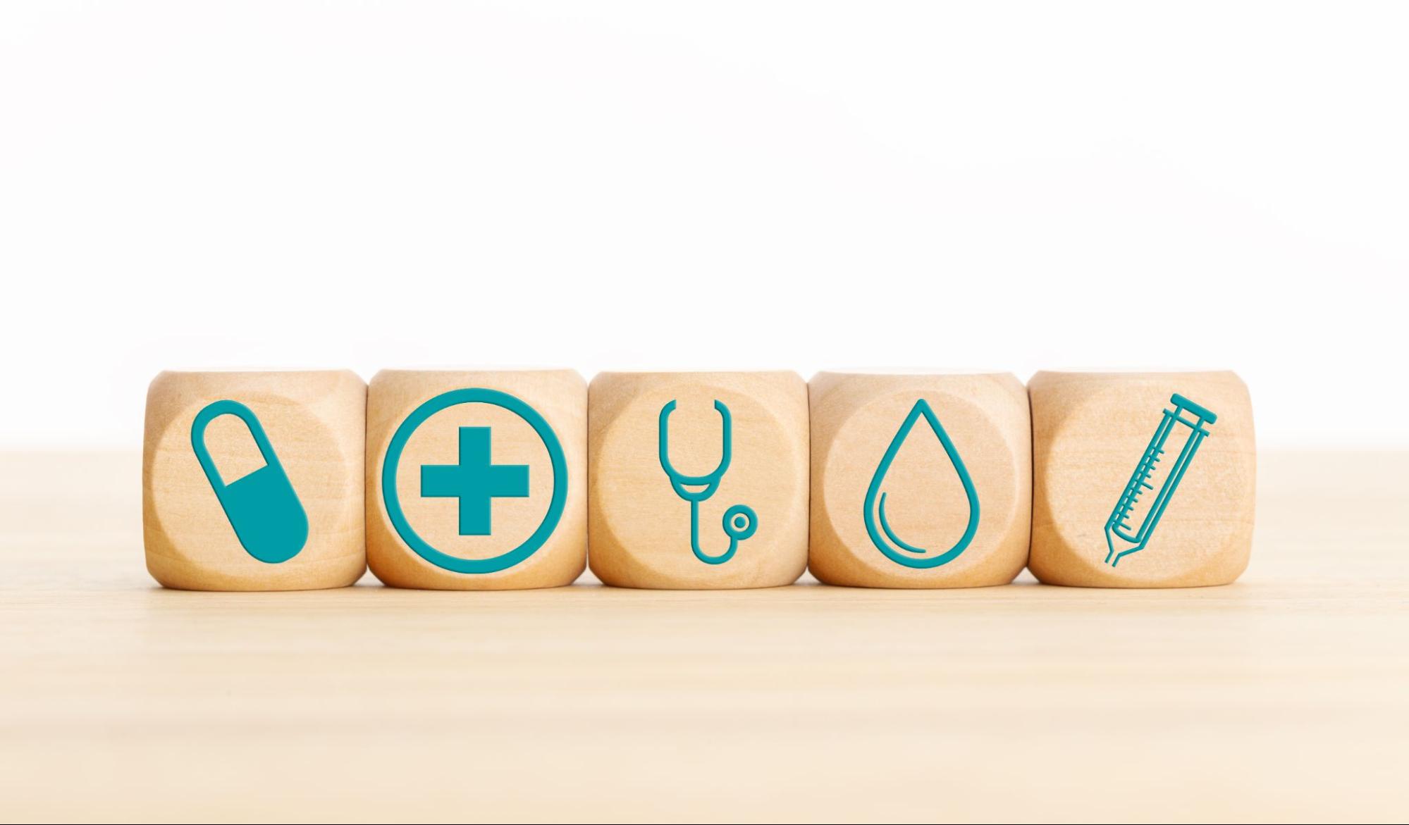 Wooden blocks with medical icons showcasing a concept of the process of wound healing on a table.