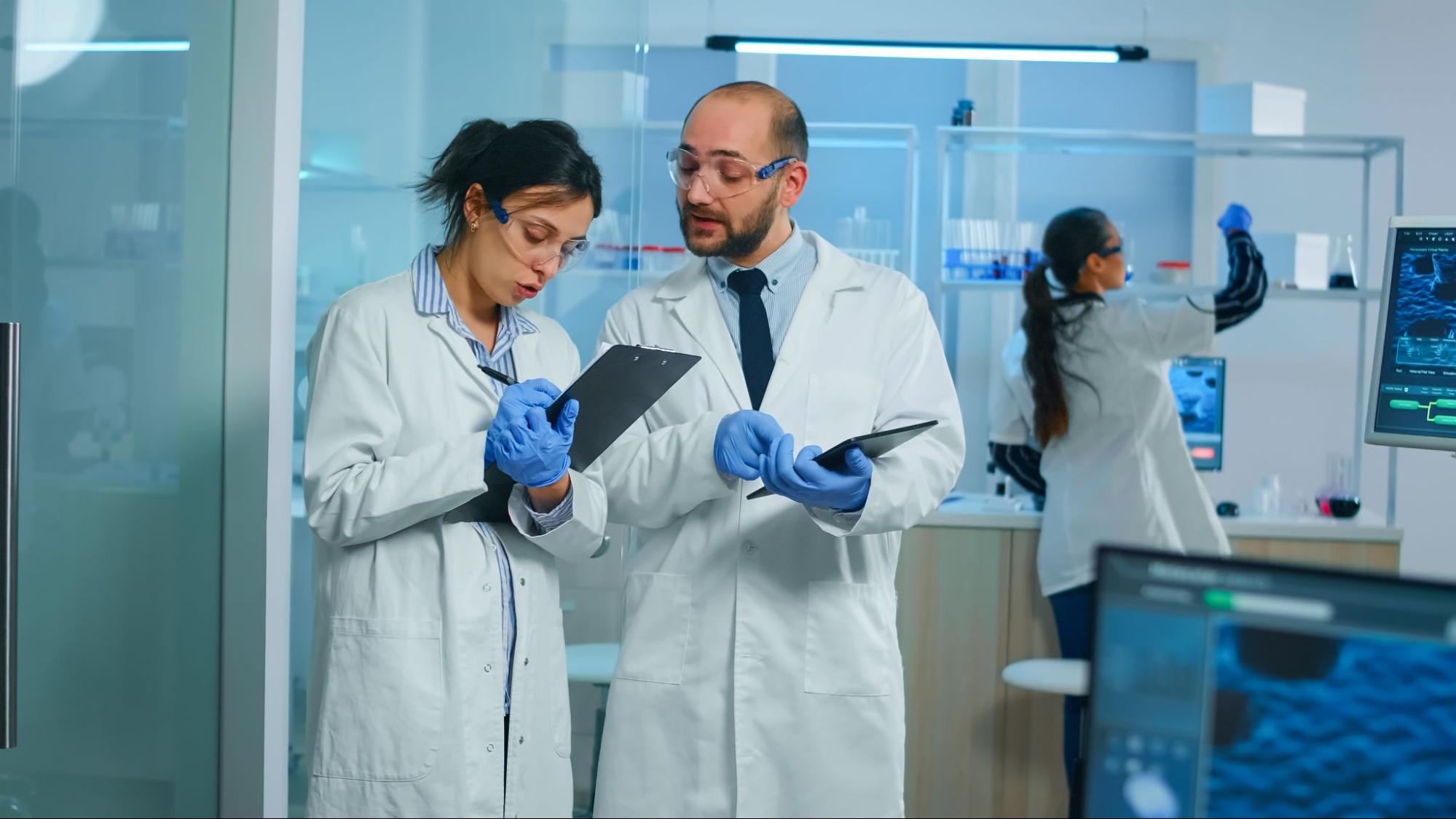 A young male scientist and two female scientists are working in a lab researching regenerative therapy.