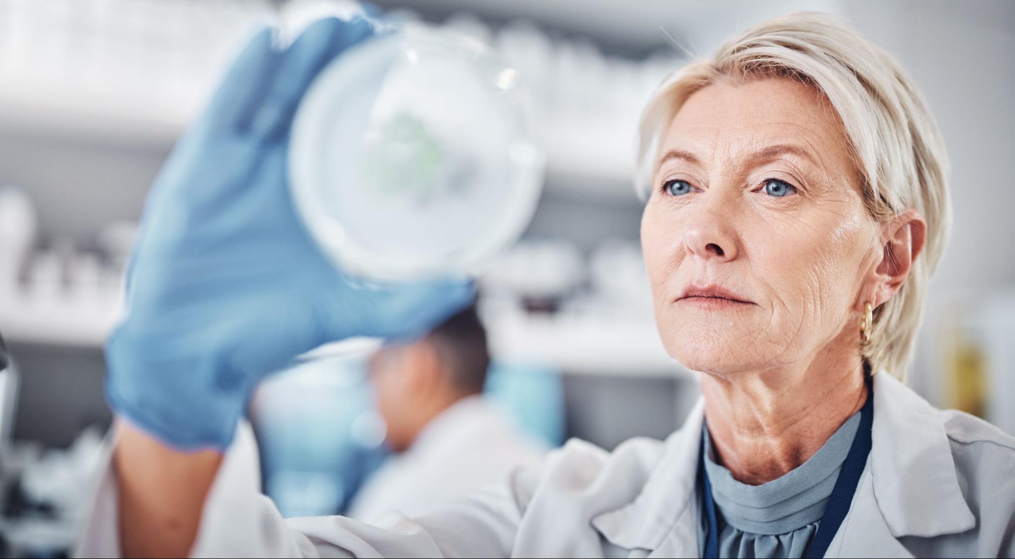 A female doctor in a biological research lab is looking at a sample.