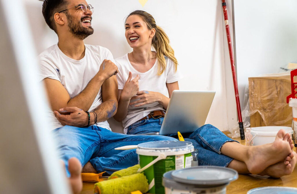A couple sits on the floor during their home improvement project break, discussing the best color combinations for each room.